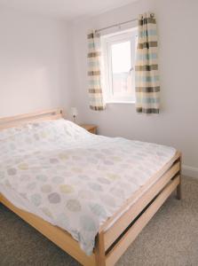 a bedroom with a bed and a window at Tennyson Cottage in Freshwater