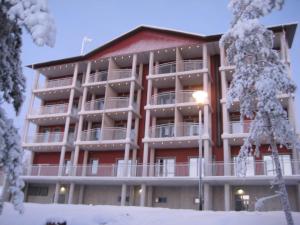 a large red building with snowcovered trees in front of it at Aparthotel Simpsiönkullas in Lapua