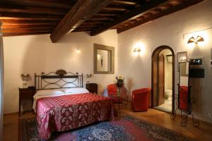 a bedroom with a bed with a red bedspread at Hotel Collodi Firenze in Florence