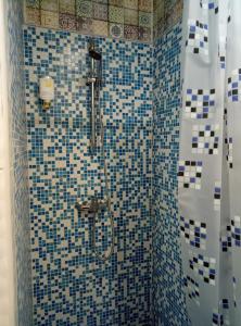 a bathroom with a shower with blue and white tiles at Hostel Svit Hub in Kamianets-Podilskyi