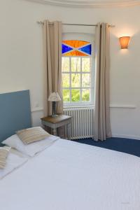 a bedroom with a white bed and a window at Auberge du Manoir d'Archelles in Arques-la-Bataille