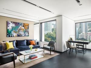 uma sala de estar com um sofá azul e uma mesa em The Murray, Hong Kong, a Niccolo Hotel em Hong Kong