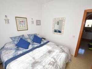 ベニタチェルにあるModern apartment in Moraira with beautiful views 5 minutes from the beachのベッドルーム(青い枕と鏡付きのベッド1台付)