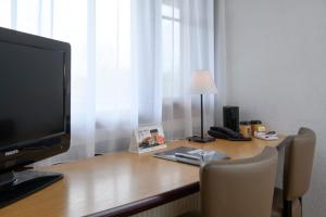 a desk with a television and a lamp on it at Campanile Hotel & Restaurant Delft in Delft