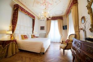 a bedroom with a white bed and a chandelier at Hotel Jolanda in Santa Margherita Ligure