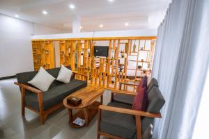 a living room with a couch and a chair and a tv at Sandy Clay Bungalows in Sihanoukville
