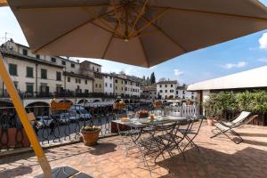 patio con tavolo, sedie e ombrellone di Apartment Matteotti a Greve in Chianti