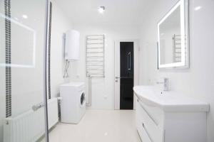 a white bathroom with a sink and a toilet at VIP Stryiska King Cross in Lviv +28 photos
