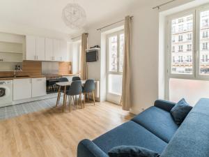 パリにあるWelkeys - Bonne Nouvelle Apartmentのリビングルーム(青いソファ付)、キッチン