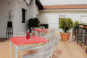 two red tables and chairs on a patio at Hotel Restaurante Irubide in Alsasua