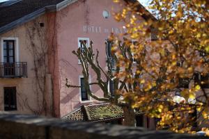 un arbre devant un bâtiment dans l'établissement Logis Hôtel de france, à La Côte-Saint-André