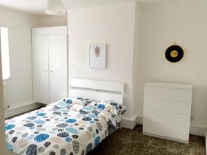 a bedroom with a bed with a blue and white comforter at Spring Lodge in Bournemouth +13 photos