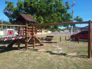 a playground with a swing set in a park at kitnet da izumi in Cabo Frio