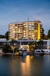 ein großes gelbes Gebäude mit einem Boot davor in der Unterkunft Cullen Bay Resorts in Darwin