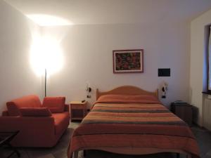1 dormitorio con 1 cama y 1 sofá en Agriturismo Quelli della Locanda Barbin, en Ne