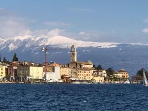 a town on the water with a mountain in the background at Piccolo Palazzo in San Felice del Benaco