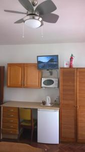 a kitchen with a desk with a tv on a ceiling at Central Suite in Funchal 3N in Funchal