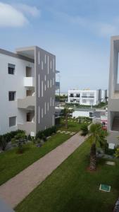 arial view of a building with a lawn and palm trees at Blanca Beach vue latérale sur mer in Sidi Rahal