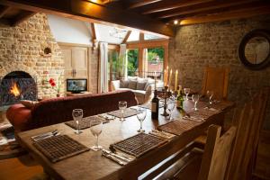 a wooden table with wine glasses on top of it at Heath Farm Holiday Cottages in Swerford