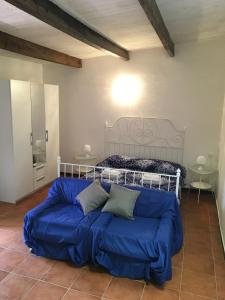 ein blaues Sofa in einem Zimmer mit einem Bett in der Unterkunft Da Lucio - Appartamento tipico nel centro storico di Sorso in Sorso