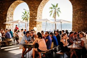 a group of people sitting at tables in a restaurant at Charming Apartment in Koper