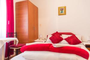 a bedroom with a red blanket on a bed at Guest House Vucicevic in Budva