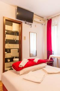 a bedroom with a large bed with a red blanket at Guest House Vucicevic in Budva