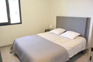 een slaapkamer met een groot bed met 2 kussens bij Camille in Porto-Vecchio