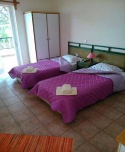 2 Betten in einem Zimmer mit Hüten darauf in der Unterkunft Maviria in Monemvasia