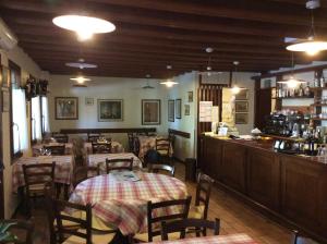ein Restaurant mit Tischen und Stühlen und eine Bar in der Unterkunft Osteria La Pesa in Ponzano Veneto