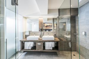 a bathroom with two sinks and a shower at Hotel Elisabeth, 4 Sterne Superior in Kirchberg in Tirol