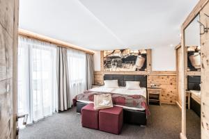 ein Hotelzimmer mit einem Bett und einem großen Fenster in der Unterkunft Hotel Elisabeth, 4 Sterne Superior in Kirchberg in Tirol