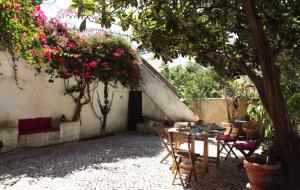 a patio with a table and chairs under a tree at Apartments of the Marques in Lisbon