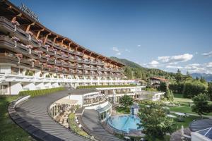 Un gran edificio con piscina y un complejo turístico. en Krumers Alpin – Your Mountain Oasis, en Seefeld in Tirol