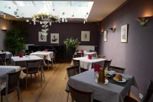 a dining room with tables and chairs in a restaurant at Focus Hotel in Kortrijk