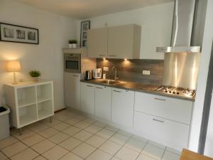 a kitchen with white cabinets and a sink at Vroeleneind in Noorbeek