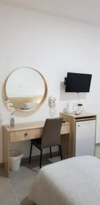 Schlafzimmer mit einem Schreibtisch, einem Spiegel und einem Stuhl in der Unterkunft Myriama Apartments in Ayia Napa