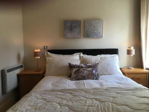 a bedroom with a large bed with pillows and two lamps at Beautiful Killarney Apartment in Killarney