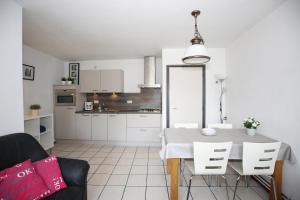 a white kitchen with a table and a chair at Vroeleneind in Noorbeek