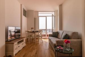 a living room with a couch and a tv and a table at PADOVA TOWER 13TH FLOOR in Padova