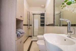 La salle de bains blanche est pourvue d'un lavabo et de toilettes. dans l'établissement PADOVA TOWER 13TH FLOOR, à Padoue