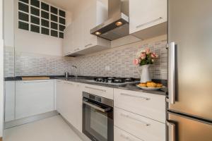 a kitchen with white cabinets and a vase of flowers at PADOVA TOWER 13TH FLOOR in Padova