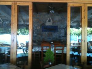 a dining room with a wooden table and a large window at Faragi in Agia Roumeli