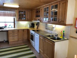 a kitchen with wooden cabinets and a sink at Vegby Bolsgård "Lillstugan" in Moheda