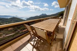 PartinelloにあるVilla U Viguの木製テーブルと椅子付きのバルコニーから眺めの良い景色を楽しめます。