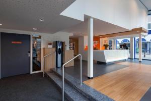un hall de bureau avec un escalier et un réfrigérateur dans l'établissement easyHotel The Hague Scheveningen Beach, à Scheveningen