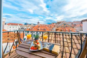 een tafel met een bord eten op het balkon bij Scalini Palace in Dubrovnik