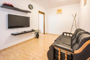 een woonkamer met een bank en een flatscreen-tv bij Ensuite Apartment A con Zona de Patio in Arrecife