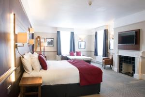 ein Hotelzimmer mit einem großen Bett und einem TV in der Unterkunft Miller & Carter Maidstone by Innkeeper's Collection in Maidstone