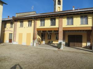 un gran edificio amarillo con una torre de reloj en Agriturismo Le Risaie, en Basiglio